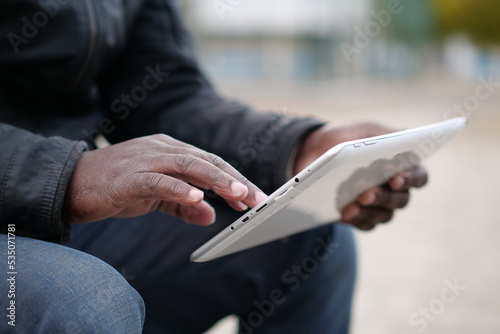 African american man works with tablet computer, close-up