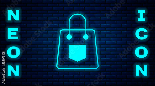 Glowing neon Handbag icon isolated on brick wall background. Female handbag sign. Glamour casual baggage symbol. Vector