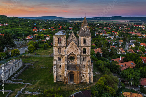 Zsambek, Hungary - Aerial view of the beautiful Premontre Monastery ruin church of Zsambek (Schambeck) with cemetery and colorful sunset at background at summertime photo