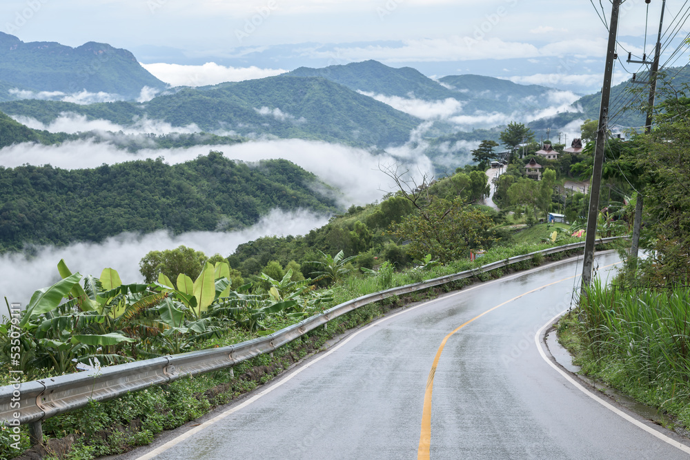 Wet asphalt road with beautiful view of misty landscape