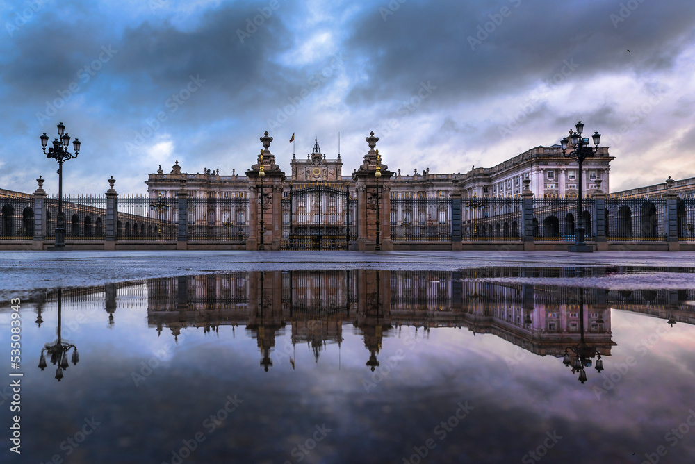 Madrid royal palace with reflection on water with cloudy blue sky