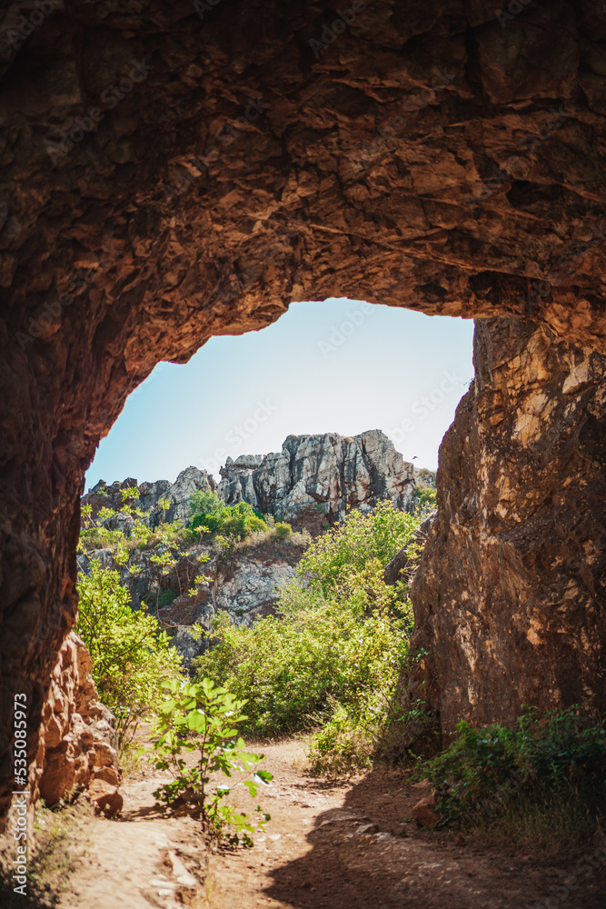 Beautiful shot of mountains from inside a cave. It is full of vegetation. (Cerro del Hierro, Spain)