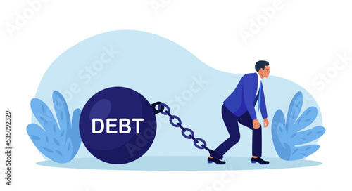 Businessman chained to heavy debt weight with shackles. Financial crisis, obligation burden. Depressed exhausted worker tied by chain to huge dumbbell. Debtor pulling his debt. Tax, fee and bankruptcy photo