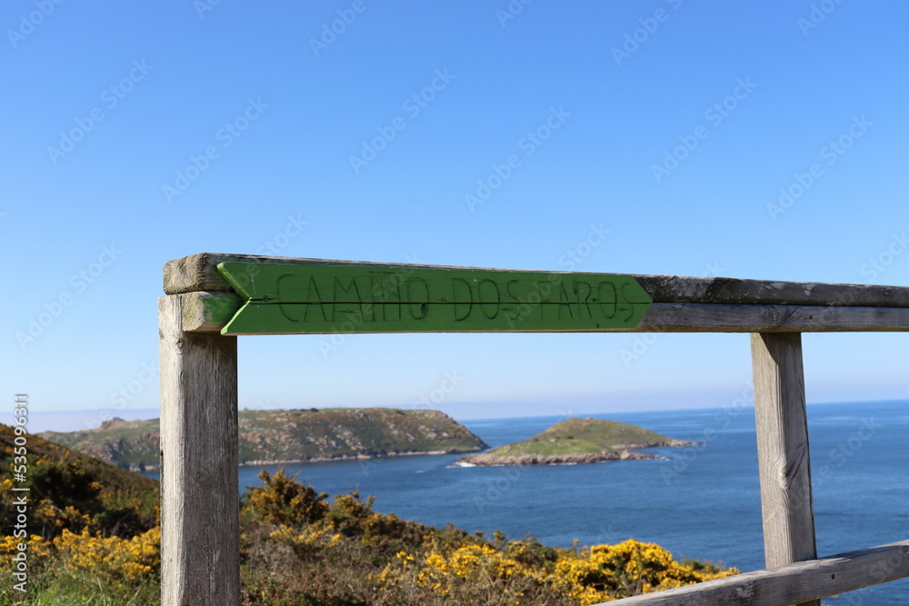 Indication of the direction of the Camiño dos Faros, a hiking route that connects Malpica with Finisterre along the seashore, in Galicia, Spain. Indication of the direction of the Camiño dos Faros, a hiking route that connects Malpica with Finisterre along the seashore, in Galicia, Spain.