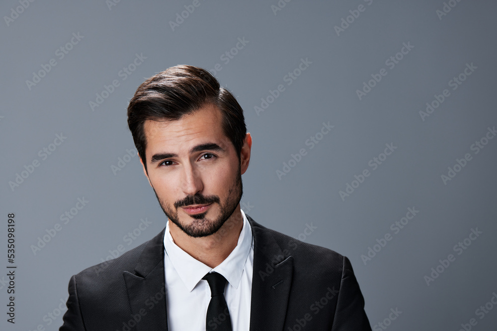 Portrait of a business man with a natural smile on a gray background in a business suit. Business portrait of a stylish man Portrait of a business man with a natural smile on a gray background in a business suit. Business portrait of a stylish man