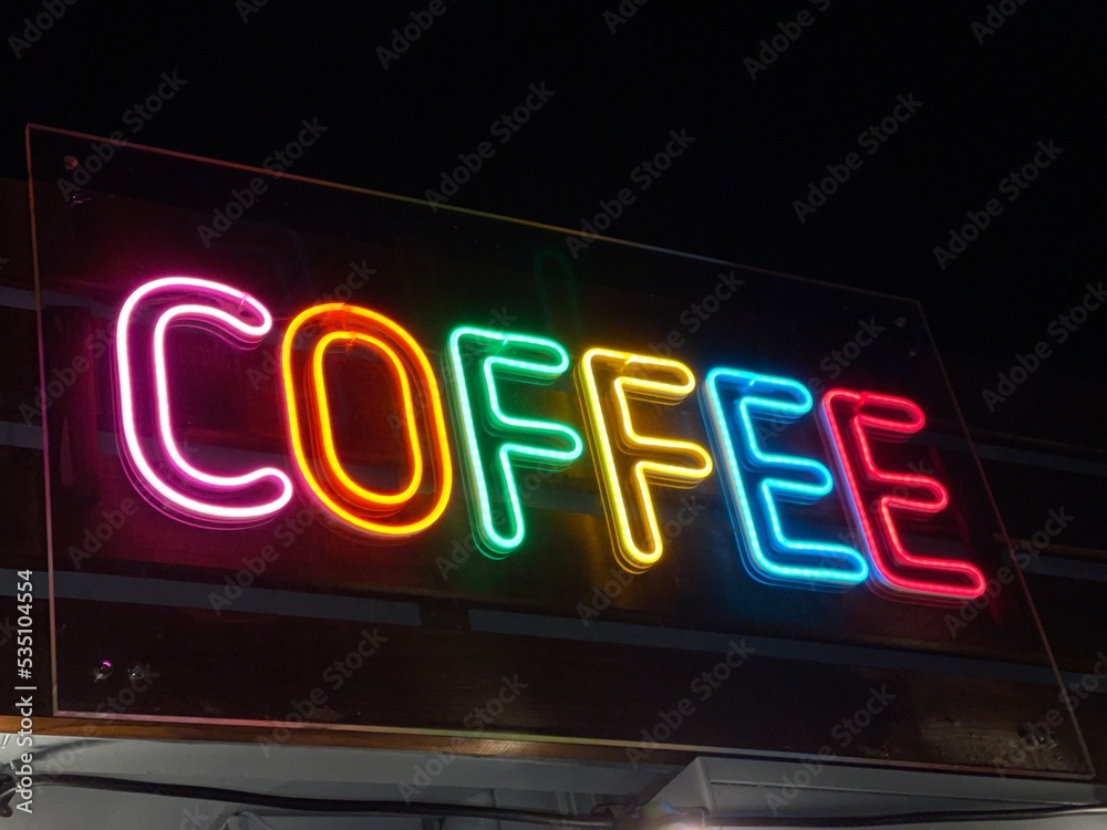 Colorful neon sign of a coffee shop glowing in the dark