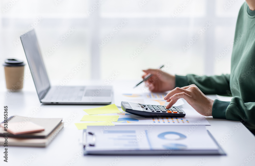 Close up of businesswoman Accounting using calculating income-expenditure and analyzing real estate investment data report Financial and tax systems concept. Close up of businesswoman Accounting using calculating income-expenditure and analyzing real estate investment data report Financial and tax systems concept.