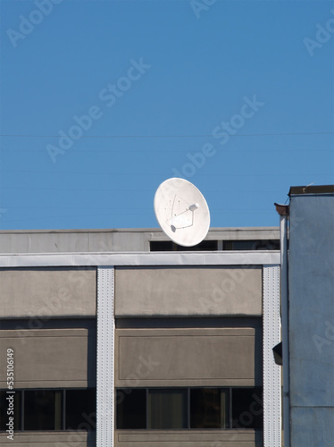 Large White Communication Dish On Building With Blue Sky