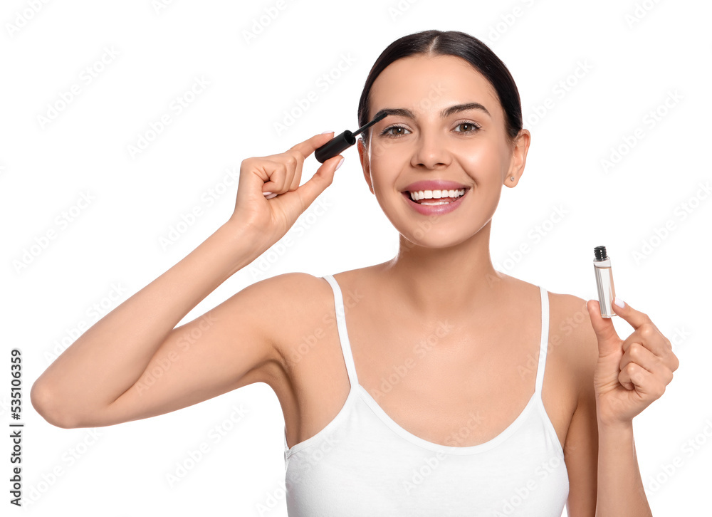 Young woman applying oil onto eyelashes on white background Young woman applying oil onto eyelashes on white background