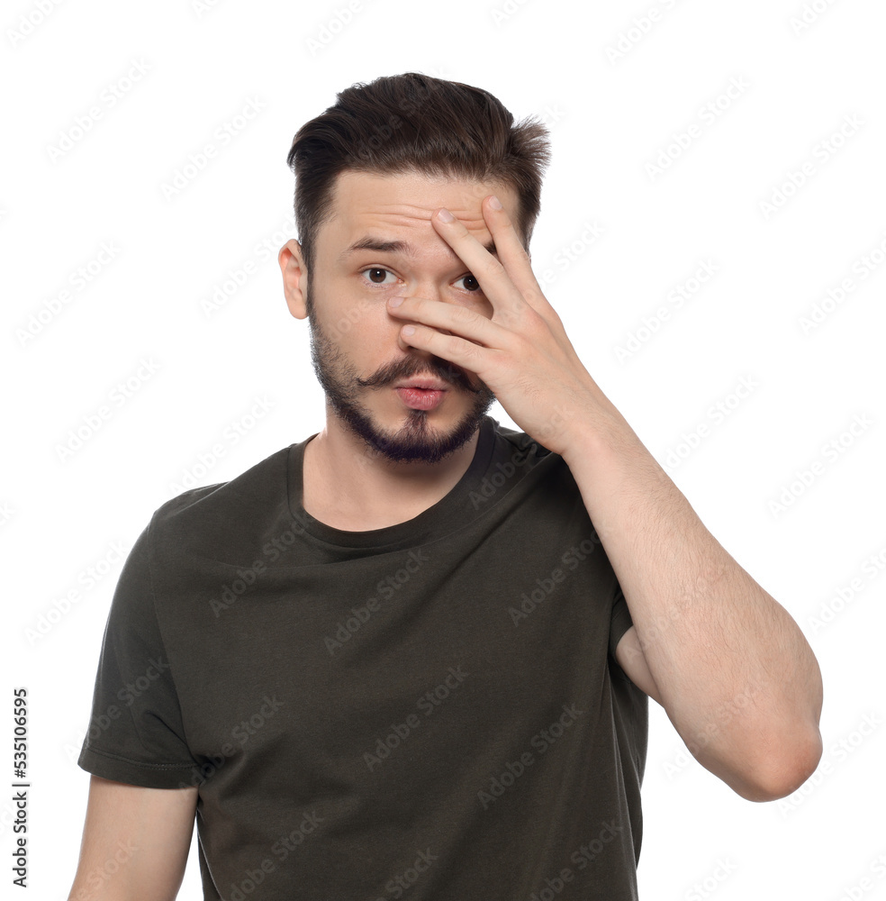 Fototapeta premium Embarrassed man covering face with hand on white background