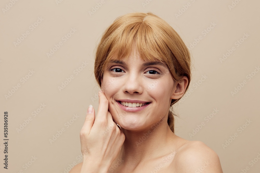 a close horizontal photo with an empty space of a pleasant, lovely woman with perfect skin standing on a background gently touching her face with her hands, smiling broadly at the camera a close horizontal photo with an empty space of a pleasant, lovely woman with perfect skin standing on a background gently touching her face with her hands, smiling broadly at the camera