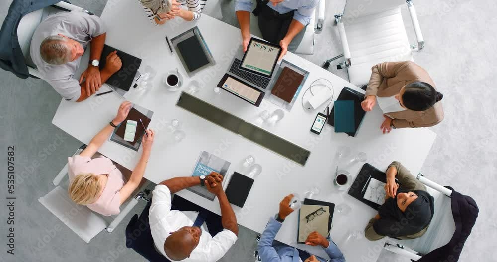 View from above of office employees together, planning through communication and collaboration at work for business goals and targets. Teamwork results in corporate productivity, efficiency and focus