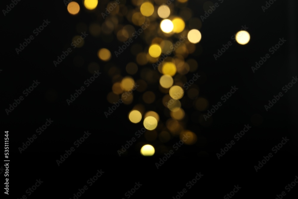 Blurred view of golden lights on black background. Bokeh effect Blurred view of golden lights on black background. Bokeh effect