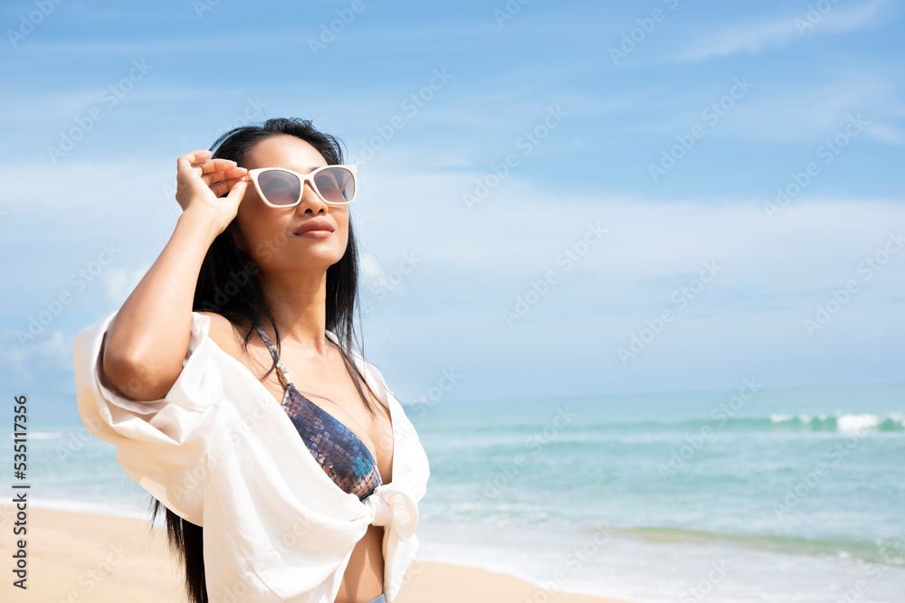 summer portrait of young sexy pretty woman, wearing simple casual trendy white tops and bright sunglasses, smiling having fun on vacation in tropical country.