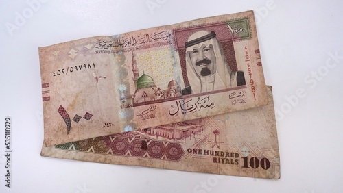 Saudi Arabia 100 riyals banknote, The Saudi riyal is the currency of Saudi Arabia, Saudi kingdom one hundred riyals with the photo of king Salman Bin Abdulaziz and Madinah mosque (obverse side) photo