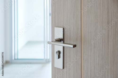 Closeup doorknob of wooden door between open or close the door © Jo Panuwat D