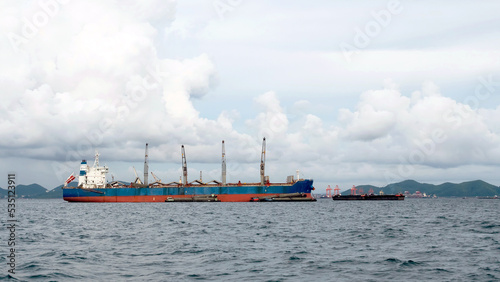 Cargo ships moored for loading and unloading at sea.