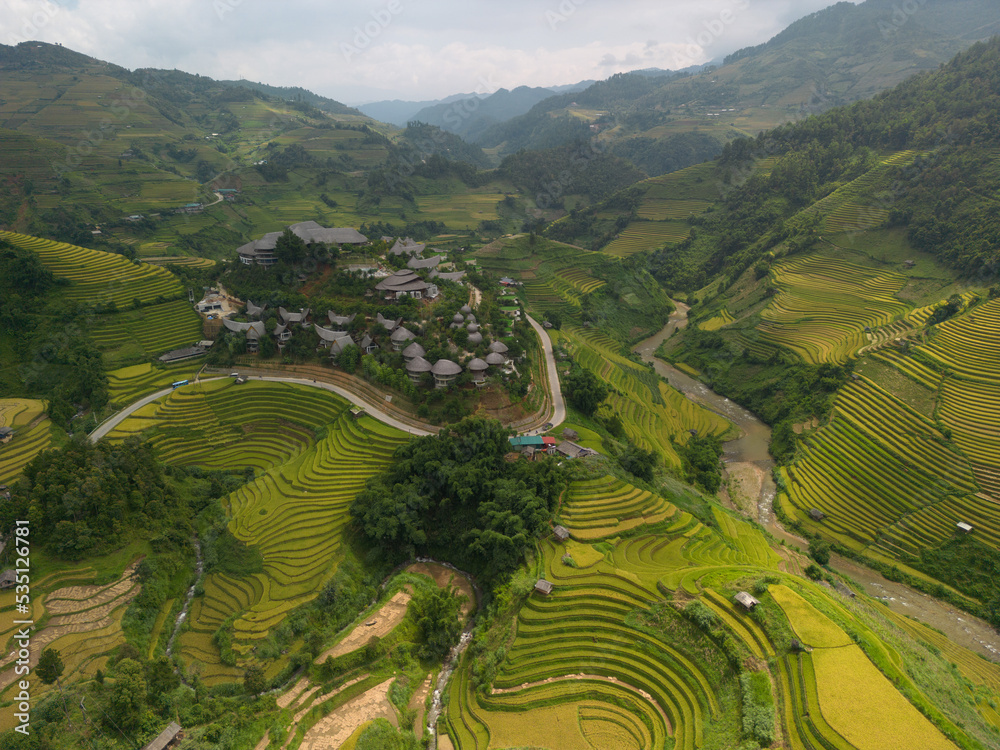 Obraz premium Aerial view of golden rice terraces at Mu cang chai town near Sapa city, north of Vietnam. Beautiful terraced rice field in harvest season in Yen Bai, Vietnam