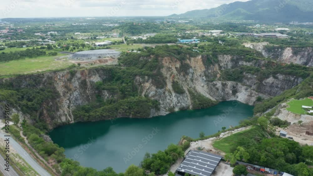 Grand Canyon Chonburi. Trucks dig coal mining of ore with black grunge ground in quarry with mountain hills. Nature landscape background in factory industry. Environment. Aerial footage b roll 4k. Grand Canyon Chonburi. Trucks dig coal mining of ore with black grunge ground in quarry with mountain hills. Nature landscape background in factory industry. Environment. Aerial footage b roll 4k.