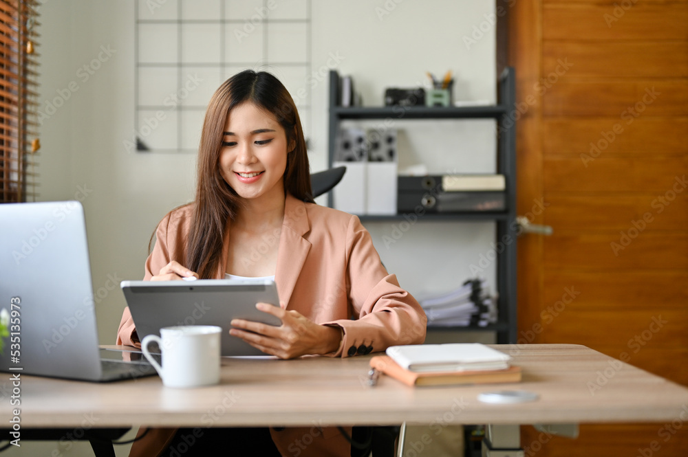Attractive Asian businesswoman using digital tablet, checking her meeting schedule. Attractive Asian businesswoman using digital tablet, checking her meeting schedule.