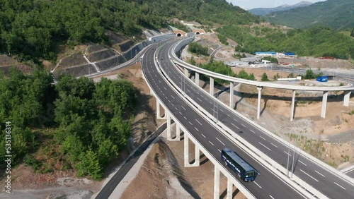 Highway interchange and off ramp on the new freeway in Montenegro. Grade-separated junction allows movement of traffic by using interconnecting roadways. Aerial drone view.