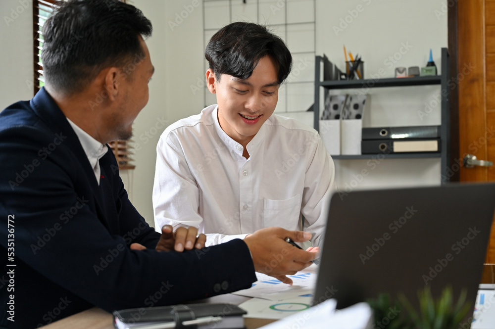 Smart Asian businessmen working, discussing and brainstorming on their project together Smart Asian businessmen working, discussing and brainstorming on their project together
