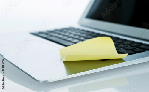Yellow sticky note on laptop keyboard