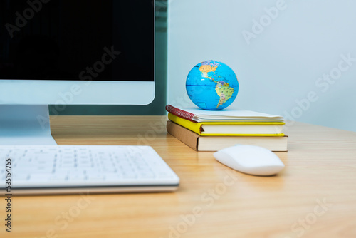 Office desk with computer and globe