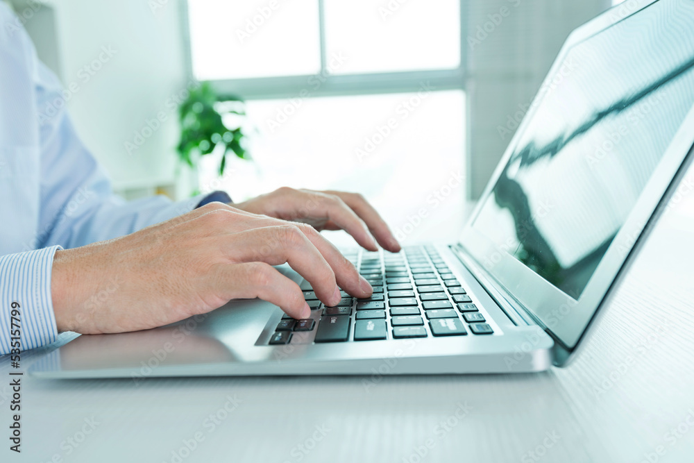 Close-up of businessman using laptop computer in office Close-up of businessman using laptop computer in office