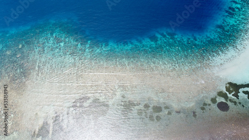 Aerial drone of healthy, pristine coral reef on Coral Triangle, layers beautiful crystal clear, turquoise, and deep blue ocean water, birds eye view, remote tropical Atauro Island, Timor Leste photo