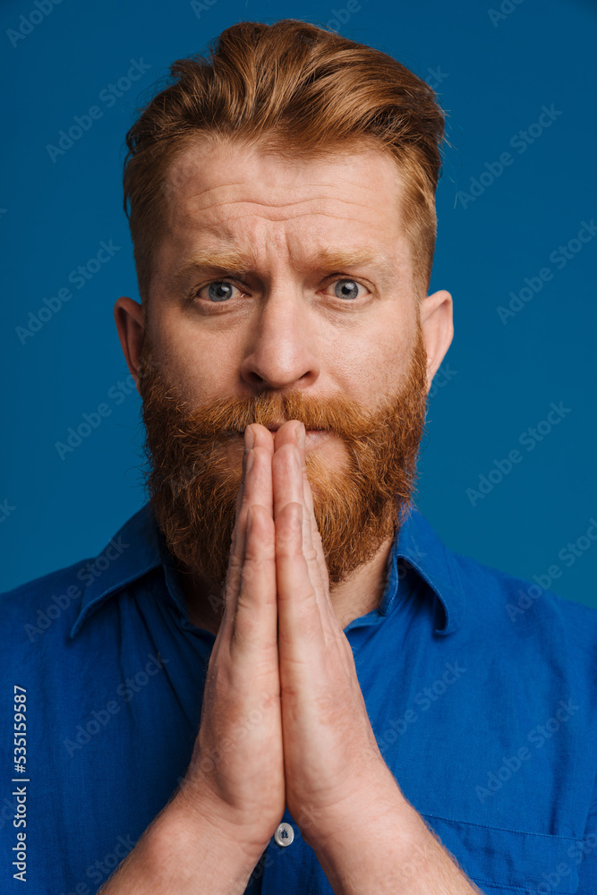 Ginger white man making pray gesture while looking at camera Ginger white man making pray gesture while looking at camera