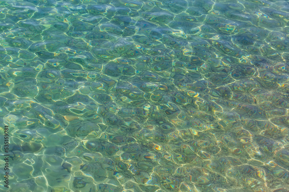 View from above to a stony seabed in clear water with abstract blue green pattern. Overview of the seabed seen from above, transparent water of the Red sea in Eilat, Israel. Seabed Background