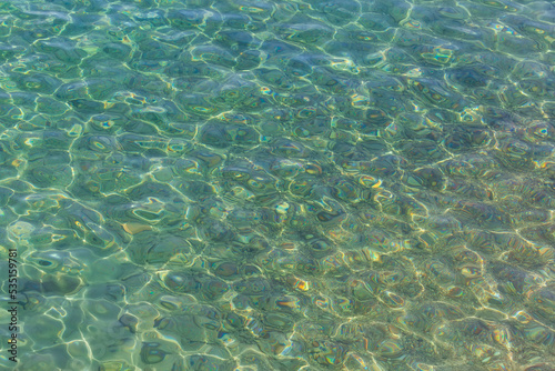 View from above to a stony seabed in clear water with abstract blue green pattern. Overview of the seabed seen from above  transparent water of the Red sea in Eilat  Israel. Seabed Background