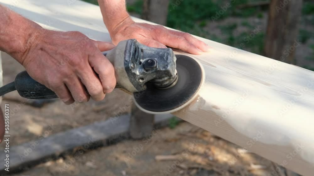 Man sanding wood with orbital sander in a workshop Man sanding wood with orbital sander in a workshop