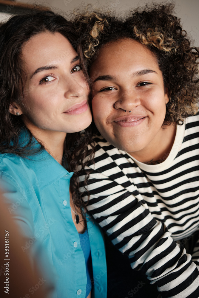 © TrueFrame Collective - Vertical medium close-up portrait of young African American and Caucasian women in love standing cheek to cheek taking selfie photo © TrueFrame Collective - Vertical medium close-up portrait of young African American and Caucasian women in love standing cheek to cheek taking selfie photo
