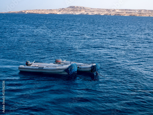 Two rubber motor boats Zodiac on the background of the blue sea and the island.