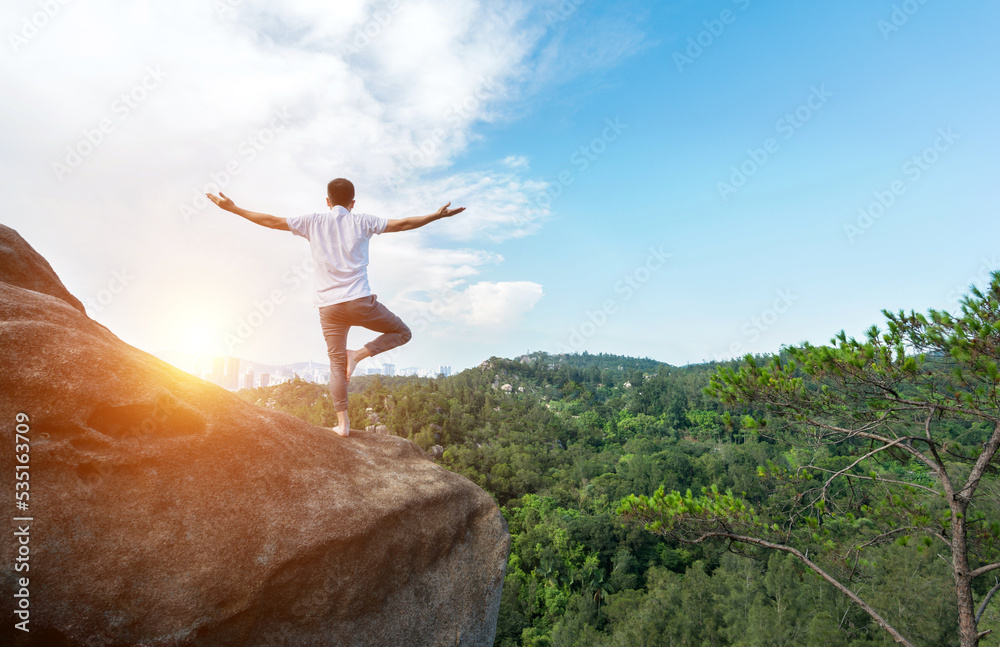 Young man doing yoga on mountain peak Young man doing yoga on mountain peak