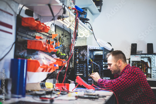 IT engineer technician repairing computer in electronics service shop