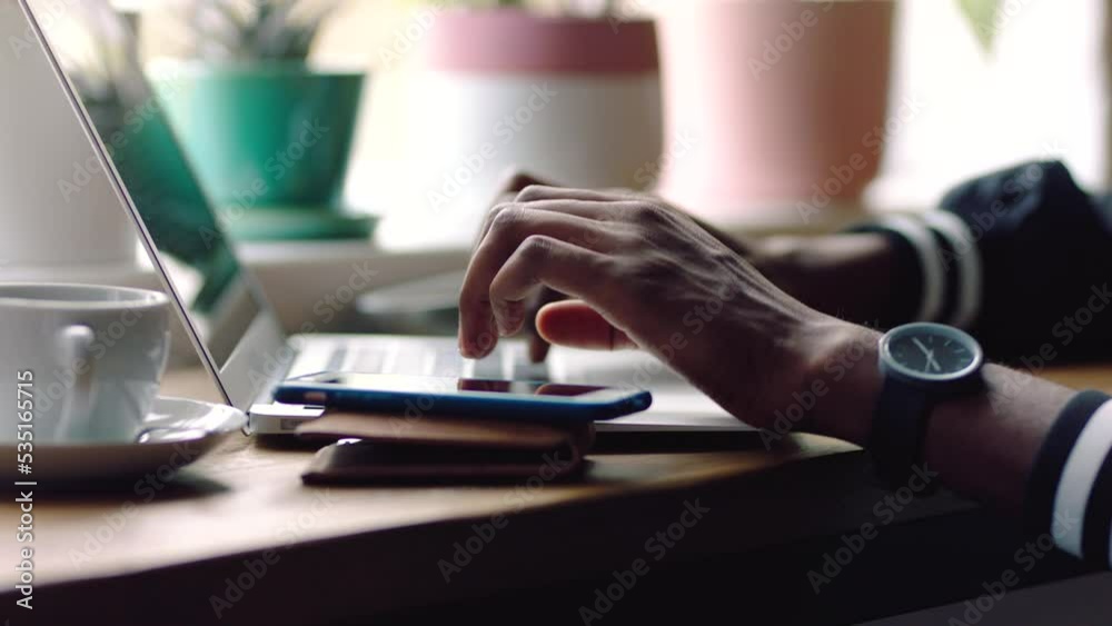Hands, laptop and phone typing in cafe for planning, blogging and working as creative freelancer. Closeup of designer man on tech keyboard, 5g mobile phone and social media apps online in coffee shop Hands, laptop and phone typing in cafe for planning, blogging and working as creative freelancer. Closeup of designer man on tech keyboard, 5g mobile phone and social media apps online in coffee shop