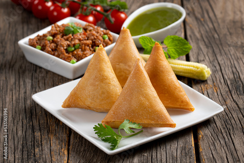 Fried indian dish samosha.Indian Delicious Deep Fried Breakfast Samosa Also Know as Samoosa isolated on Wooden texture Background
