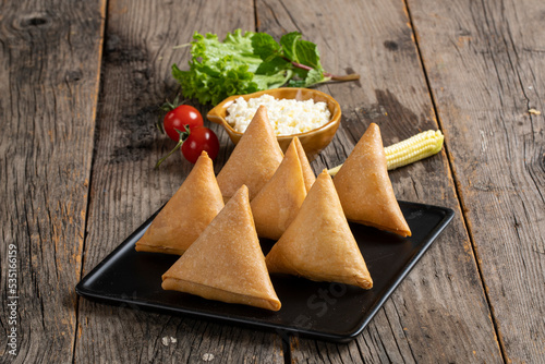 Sweet, tasty, fried indian dish samosha.Indian Delicious Deep Fried Breakfast Samosa Also Know as Samoosa isolated on Wooden texture Background