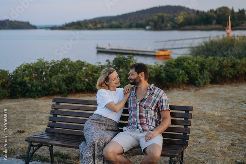 happy loving caucasian couple sitting by the lake