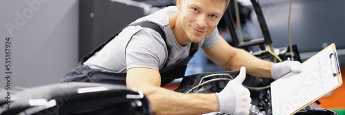 Car maintenance service male show thumbs up and happily smile with clipboard