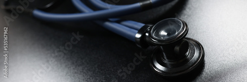 Doctor stethoscope equipment on dark surface, tool for patient diagnostic