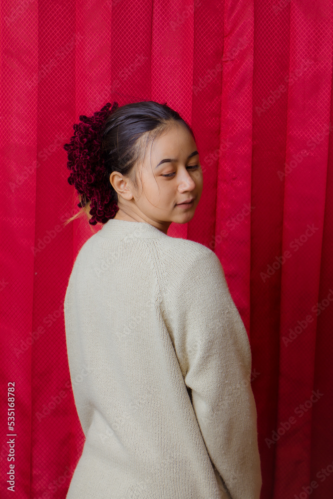 Portrait of cheerful beautiful Asian Woman in casual shirt. Beautiful asian female model posing in studio on red background. Portrait of cheerful beautiful Asian Woman in casual shirt. Beautiful asian female model posing in studio on red background.
