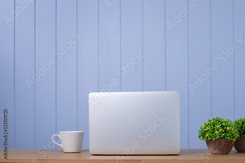 laptop on wood table with cup of coffee.