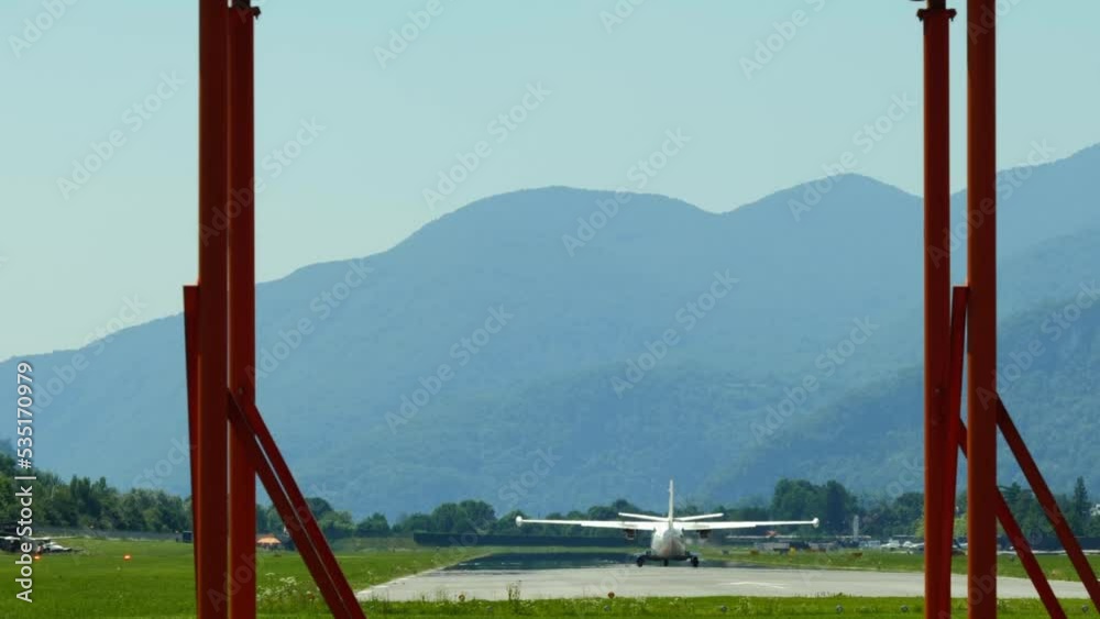 Airplane Taking Off from Lugano Airport with Mountain View and Flying Against Blue Sky with Clouds in Ticino, Switzerland. Airplane Taking Off from Lugano Airport with Mountain View and Flying Against Blue Sky with Clouds in Ticino, Switzerland.