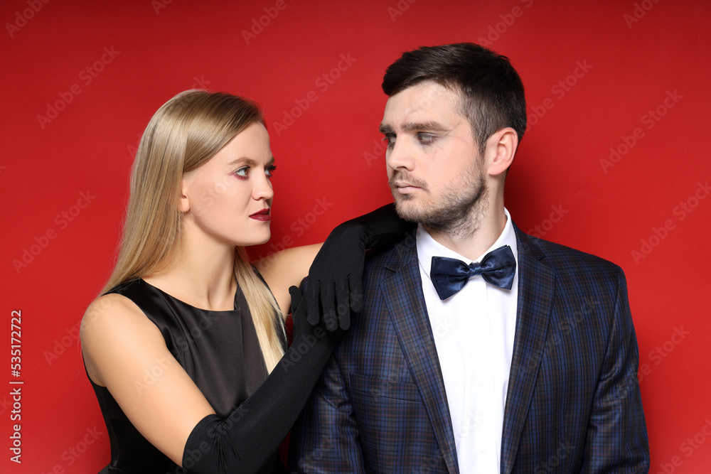 Concept of Halloween, young man and woman on red background Concept of Halloween, young man and woman on red background