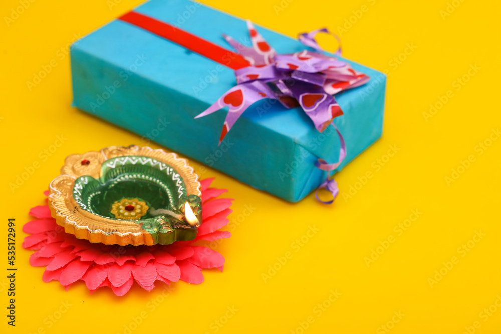 Indian Festival diwali concept. Gift box and oil lamp on yellow