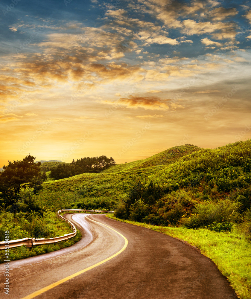 Fototapeta premium Curved asphalt road in high mountains at sunrise